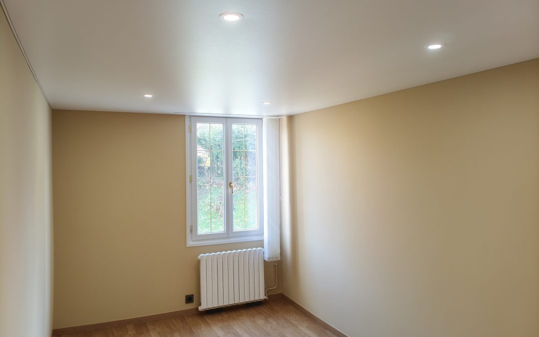 Chambre rénovée à Bonneuil-les-Eaux, murs beige et plafond tendu blanc mat avec spots encastrés.