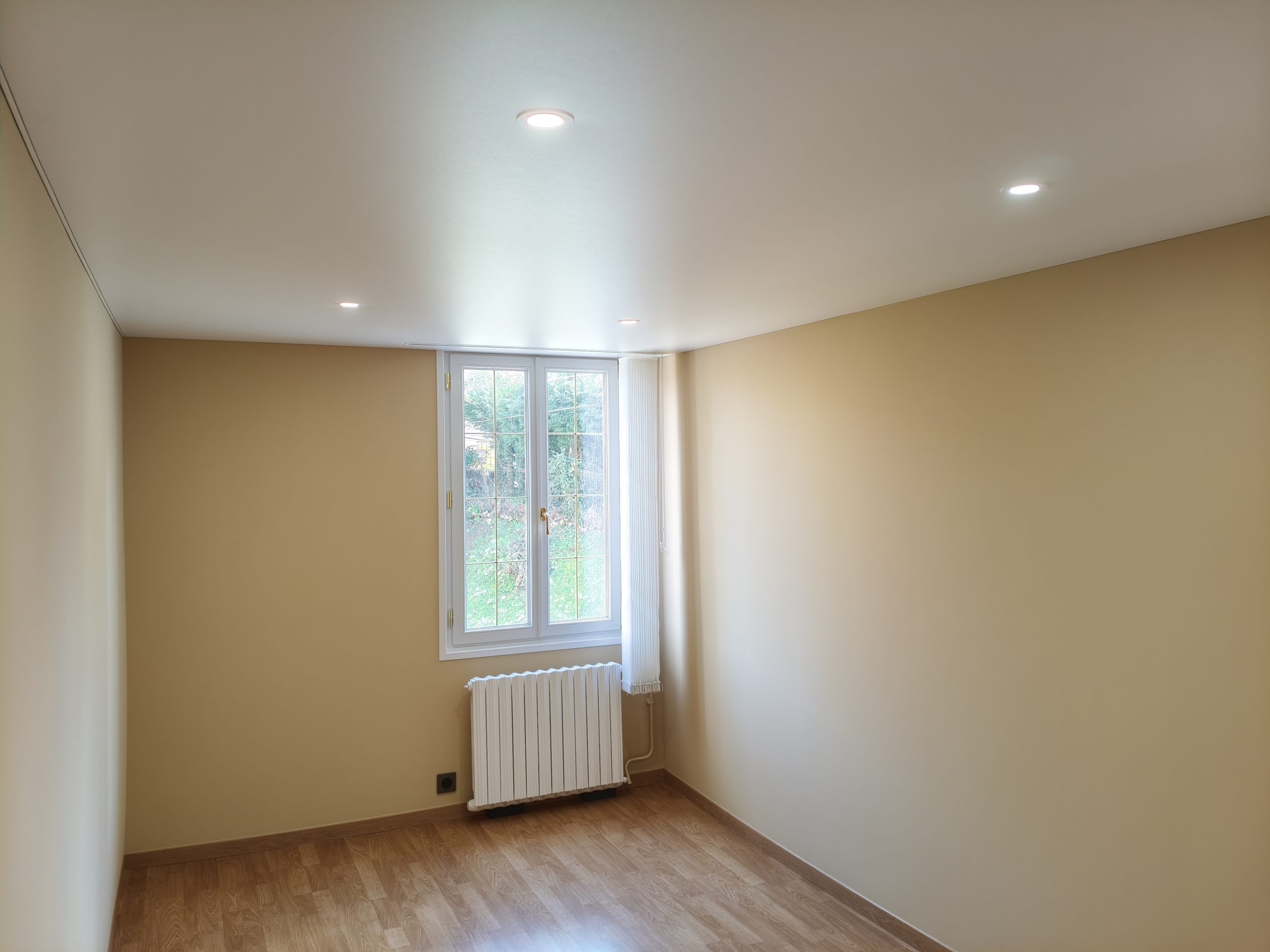 Chambre rénovée à Bonneuil-les-Eaux, murs beige et plafond tendu blanc mat avec spots encastrés.